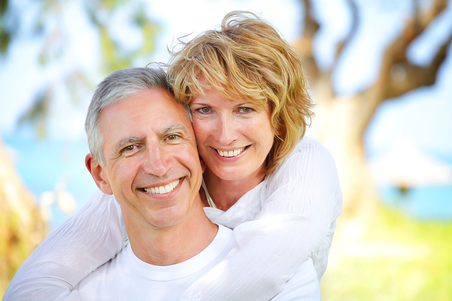 mature couple smiling near beach, Urbana, MD dental implants